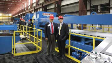 John & Jock Buta in front of a Stretch Leveling Cut-To-Length line